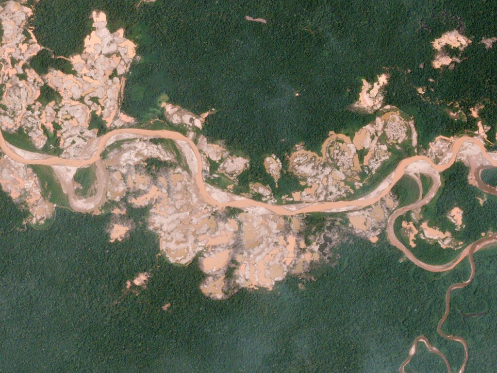 Satellite view of mining clearings and pits along the Malinowski River in the La Pampa area near Tambopata National Reserve.
